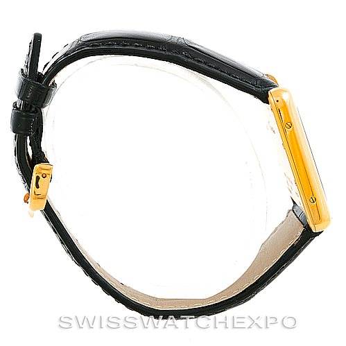 The side angle shows the Tank Louis watch by Cartier with a black leather strap and a gold rectangular case.