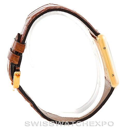 This Cartier Tank Louis W1529756 Men's Yellow Gold Silver Dial W1529756 Men's Yellow Gold Silver Dial model watch is shown from a side angle, showcasing the leather strap and the thin rectangular case.