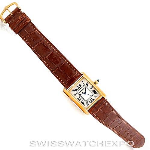 The Cartier Tank Louis W1529756 Men's Yellow Gold Silver Dial W1529756 Men's Yellow Gold Silver Dial watch is shown from an overhead angle, displaying its rectangular face, brown leather strap, and gold case.