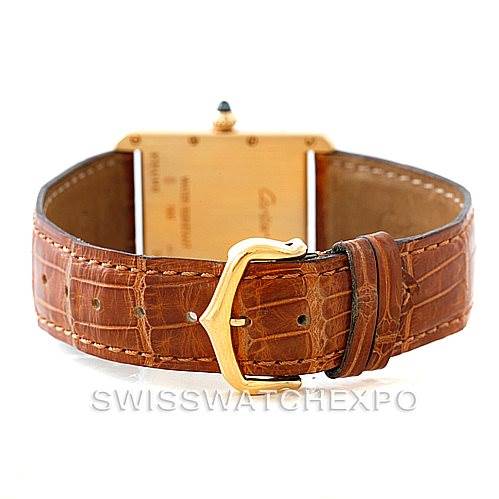 The image shows the Tank Louis Cartier watch from the back, highlighting the brown leather strap and gold buckle.