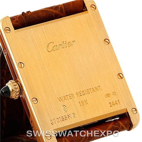 This image shows the back case of a Cartier Tank Louis W1529756 Men's Yellow Gold Silver Dial W1529756 Men's Yellow Gold Silver Dial watch in 18K gold with an encased screw-down crown adorned with a blue gemstone.