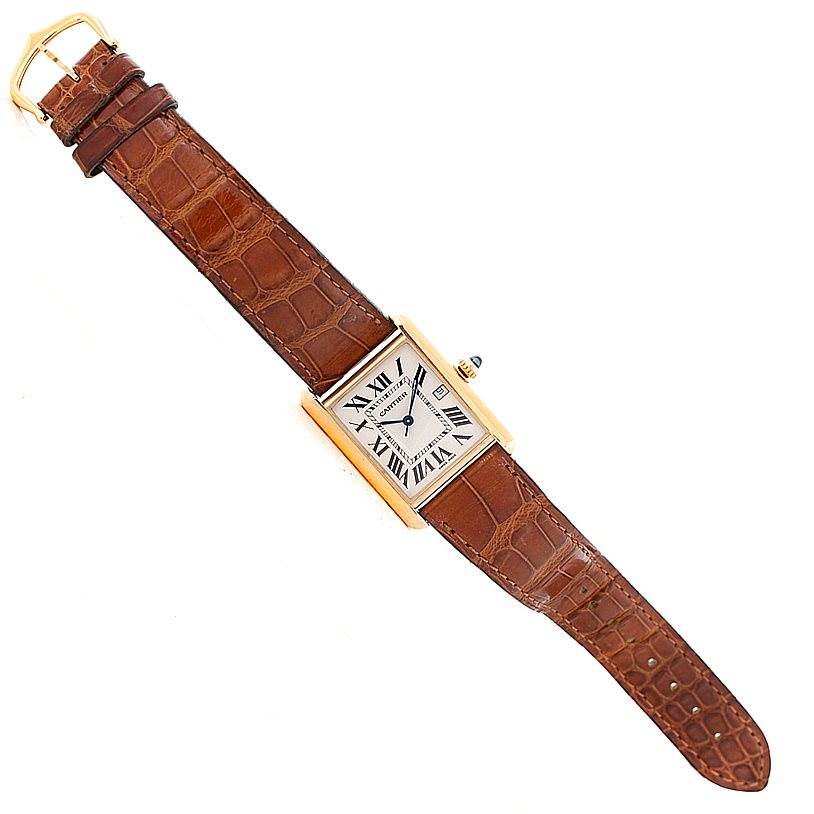 The Cartier Tank Louis W1529756 Men's Yellow Gold Silver Dial W1529756 Men's Yellow Gold Silver Dial watch is shown from a top-down angle, displaying its brown leather strap and rectangular watch face with Roman numerals.