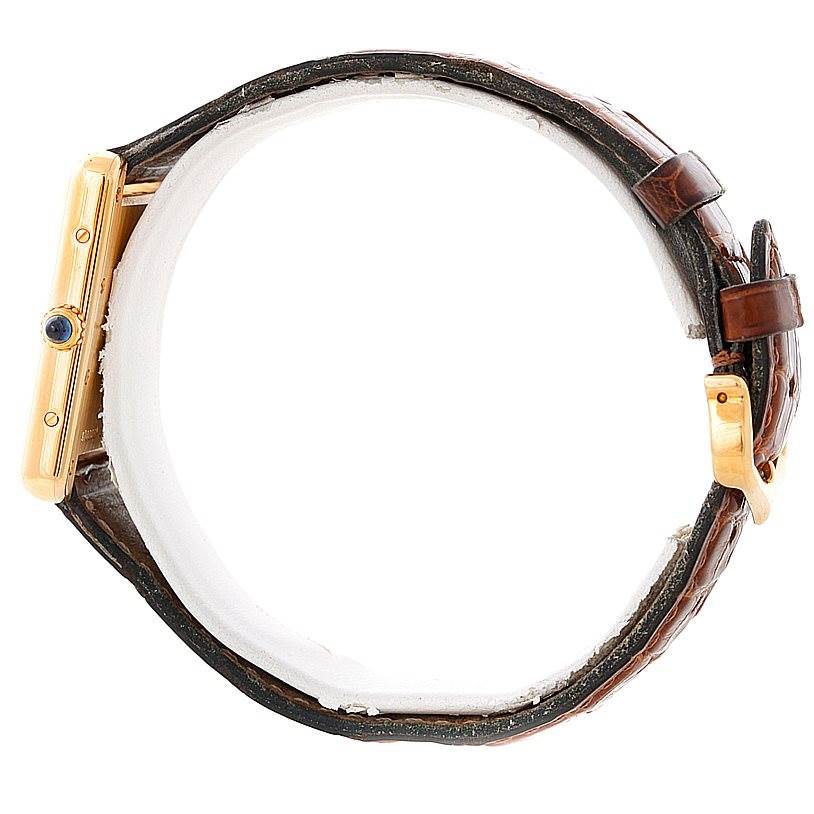 The image shows the Tank Louis model by Cartier from a side angle, highlighting its crown, case, and leather strap.