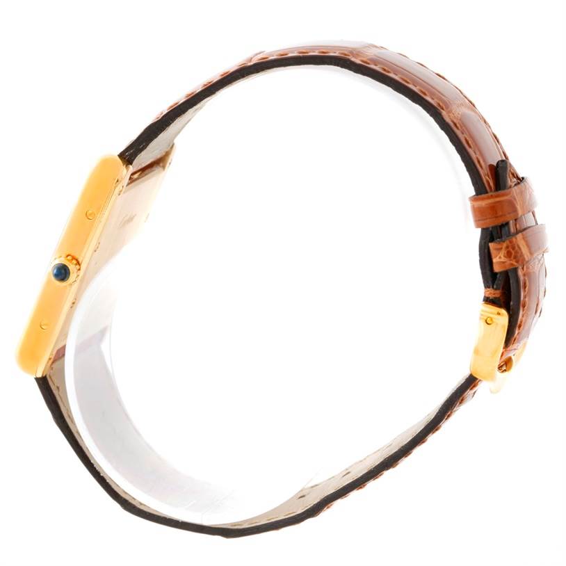 The image shows a side view of the Tank Louis model by Cartier, highlighting the crown and leather strap.