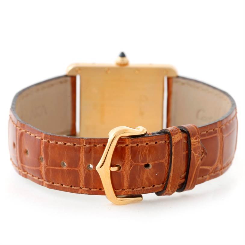 This image shows a rear view of a Cartier Tank Louis W1529756 Men's Yellow Gold Silver Dial W1529756 Men's Yellow Gold Silver Dial watch, highlighting its brown leather strap and gold buckle.