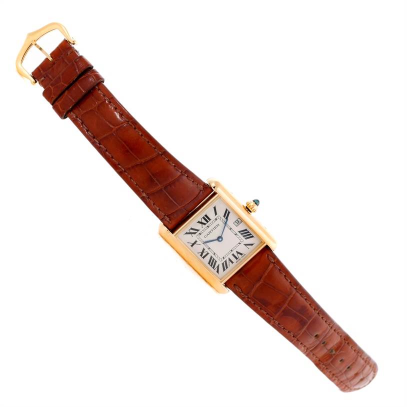 The image shows the Cartier Tank Louis W1529756 Men's Yellow Gold Silver Dial W1529756 Men's Yellow Gold Silver Dial watch with a brown leather strap, gold case, and white dial with Roman numerals, at an angled view.