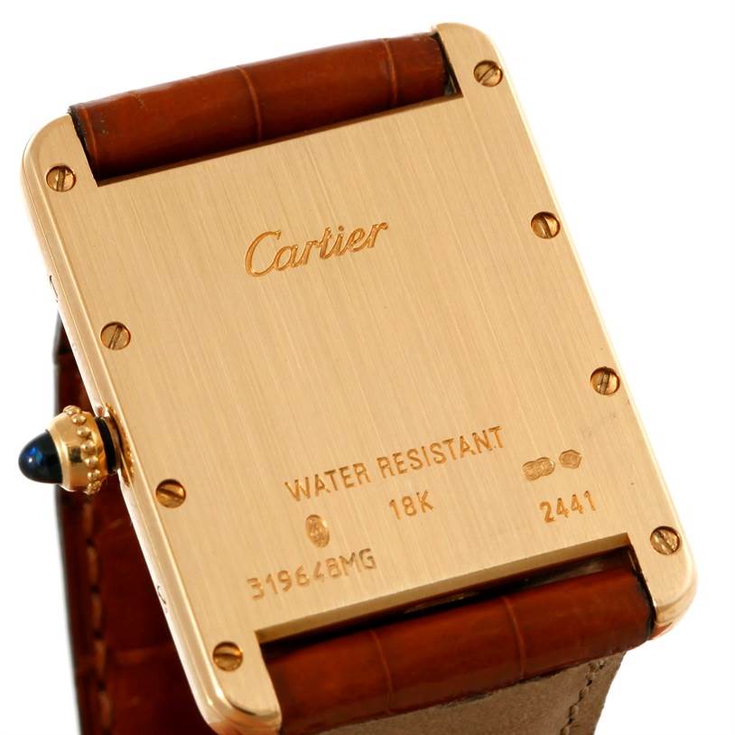 The image shows the back of a Cartier Tank Louis W1529756 Men's Yellow Gold Silver Dial W1529756 Men's Yellow Gold Silver Dial watch, highlighting its gold case, screws, and engraved details.