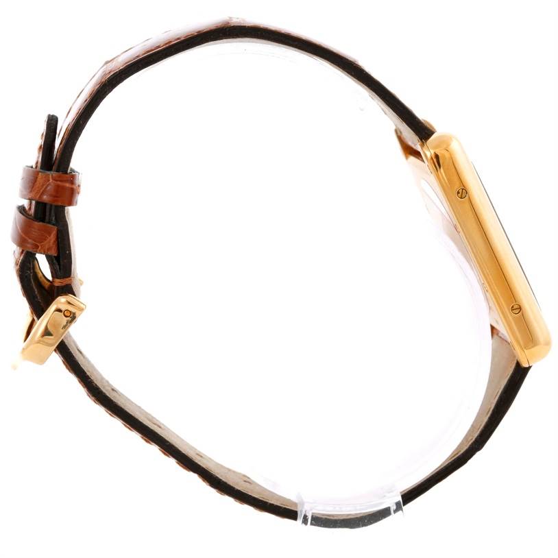 The image shows a side profile of a Tank Louis watch by Cartier, highlighting the watch case, strap, and buckle.