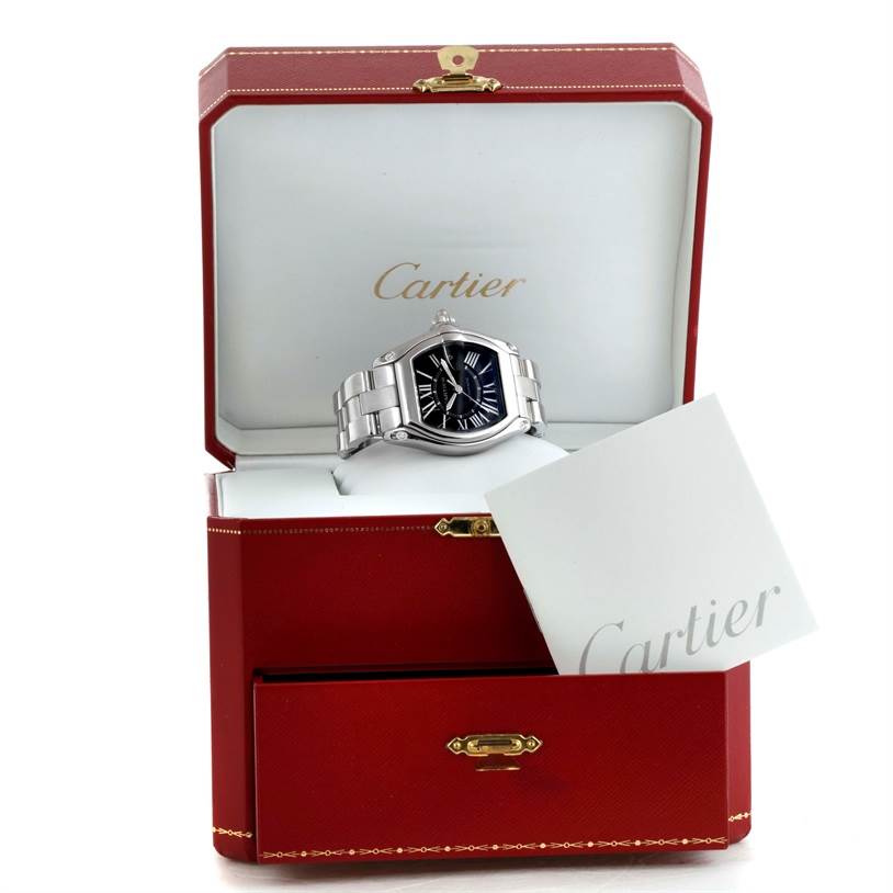 The Cartier Roadster W62041V3 Men's Stainless Steel Black Dial W62041V3 Men's Stainless Steel Black Dial watch is shown from the front angle, inside its open box with visible branding and a booklet.