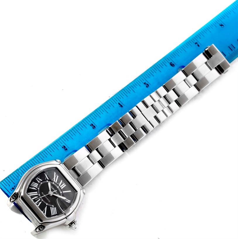 The image shows a Cartier Roadster W62041V3 Men's Stainless Steel Black Dial W62041V3 Men's Stainless Steel Black Dial model watch laid flat with its bracelet partially measured against a blue ruler.