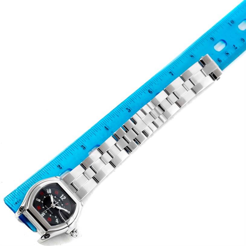 The image shows a Cartier Roadster W62002V3 Men's Stainless Steel Black Dial W62002V3 Men's Stainless Steel Black Dial watch placed next to a blue ruler, highlighting the watch face and stainless steel bracelet.