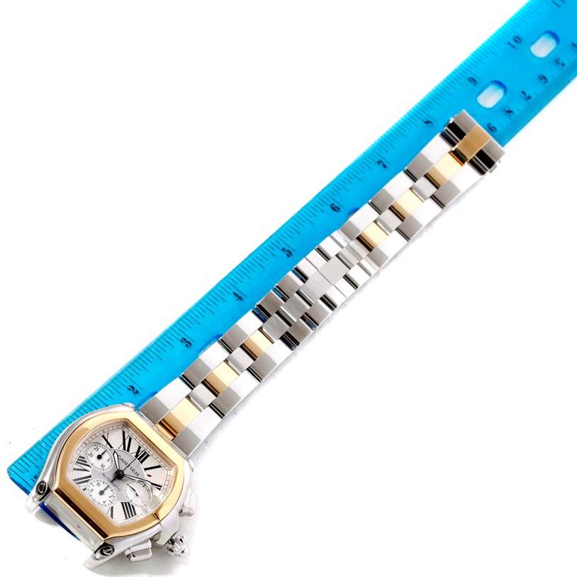 The Cartier Roadster W62027Z1 Men's Steel and Gold (two tone) Silver Dial W62027Z1 Men's Steel and Gold (two tone) Silver Dial watch is shown from an overhead angle, displaying the face and entire band next to a blue ruler for size reference.