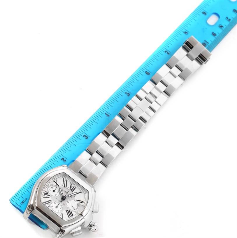 The image shows the Roadster model by Cartier, displaying the face and bracelet while laid next to a blue ruler for measurement.