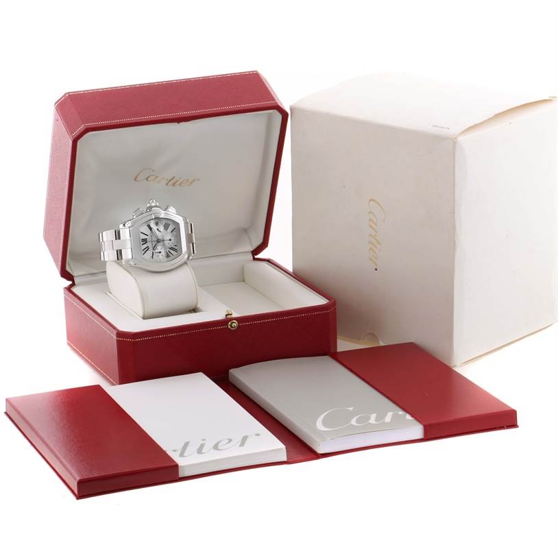 The Cartier Roadster W62019X6 Men's Stainless Steel Silver Dial W62019X6 Men's Stainless Steel Silver Dial watch is shown in its open case with additional booklets and packaging.
