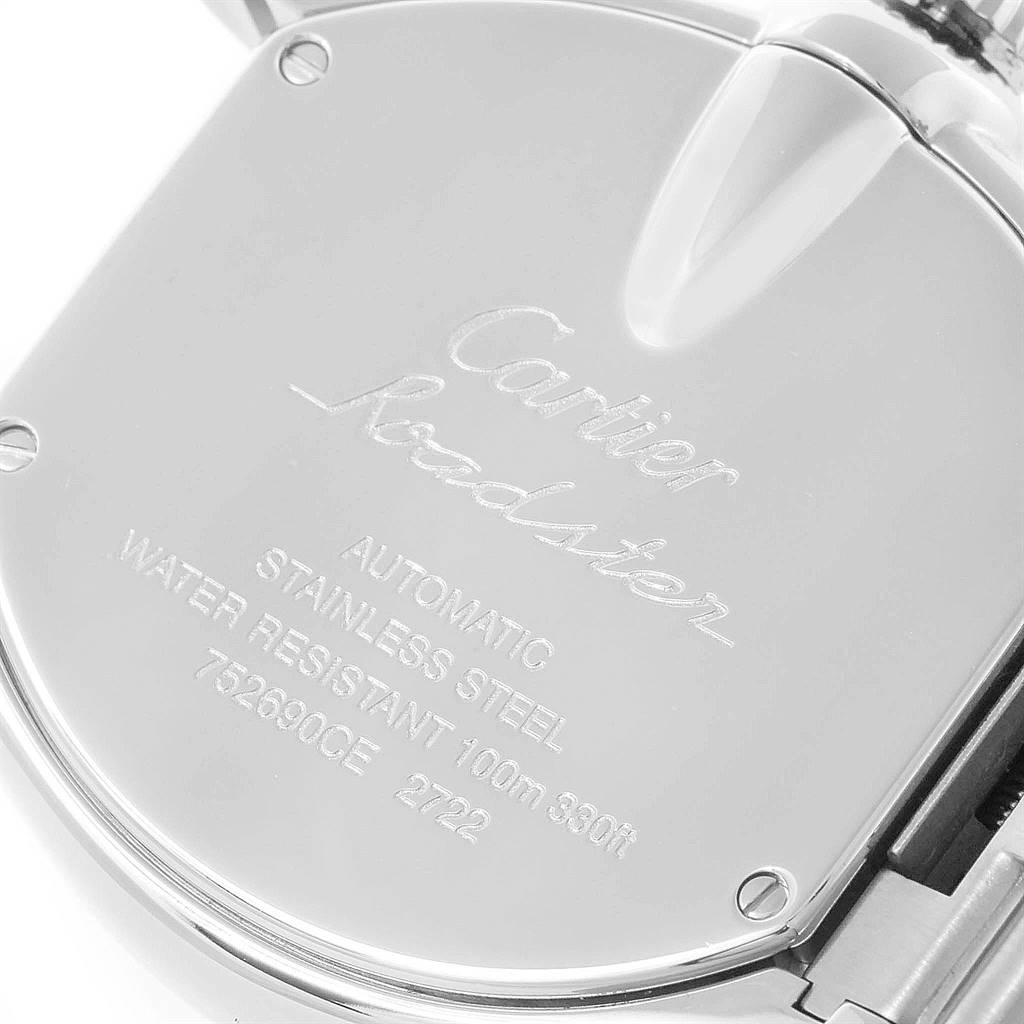 The image shows the back case of a Cartier Roadster W62032X6 Men
s Stainless Steel Silver Dial W62032X6 Men
s Stainless Steel Silver Dial watch with its engravings and part of the bracelet.