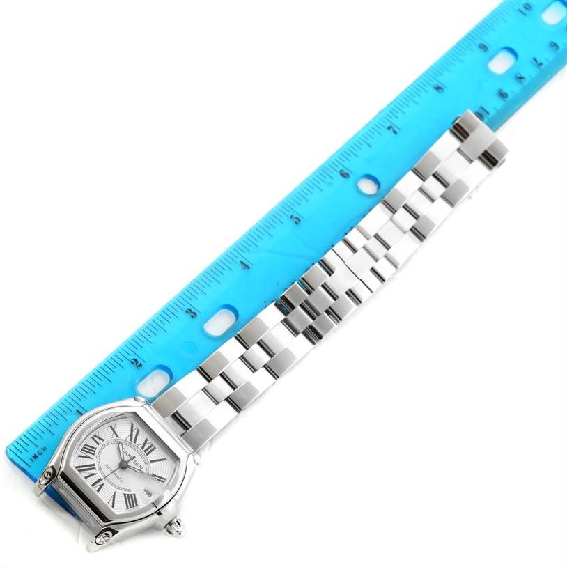 The Cartier Roadster W62025V3 Men's Stainless Steel Silver Dial W62025V3 Men's Stainless Steel Silver Dial watch is shown horizontally with the face and stainless steel bracelet fully visible next to a blue ruler.