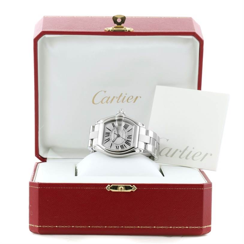 The Cartier Roadster W62025V3 Men's Stainless Steel Silver Dial W62025V3 Men's Stainless Steel Silver Dial watch is shown at a front angle, displayed in its open red case with a booklet.