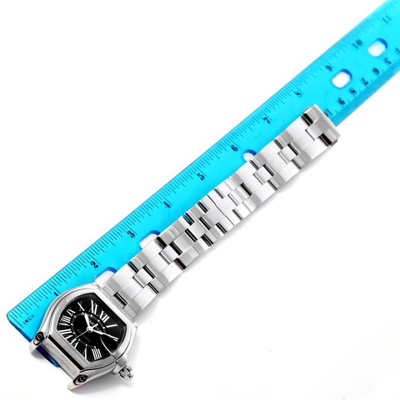 The Cartier Roadster W62041V3 Men's Stainless Steel Black Dial W62041V3 Men's Stainless Steel Black Dial watch is shown with a face-up view, placed next to a blue ruler for scale.