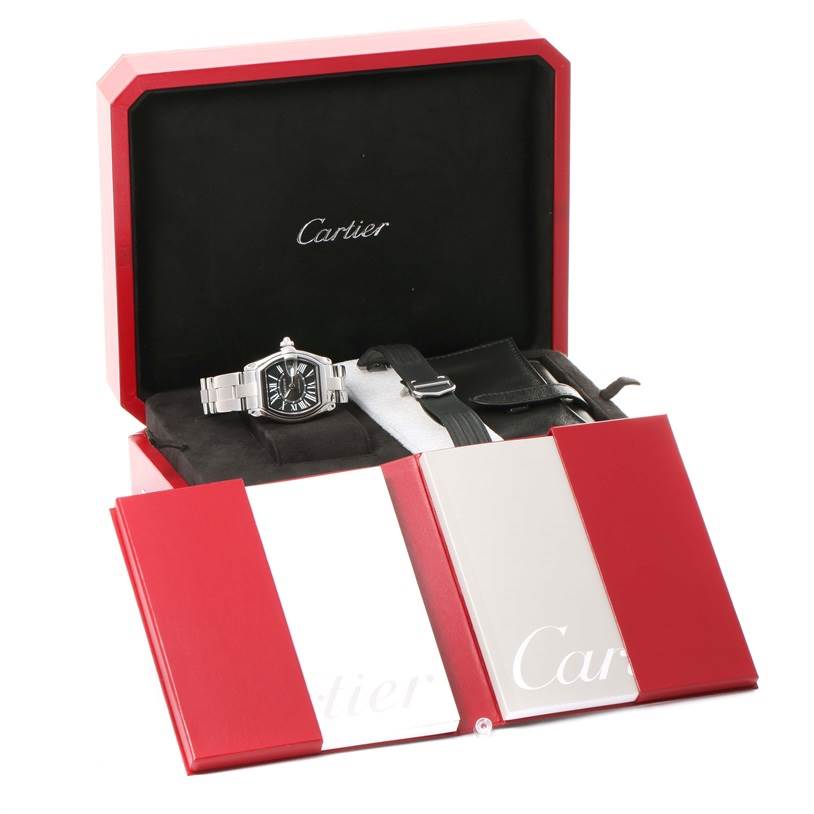 The Cartier Roadster W62041V3 Men's Stainless Steel Black Dial W62041V3 Men's Stainless Steel Black Dial watch is shown in its open box with additional straps and documentation.