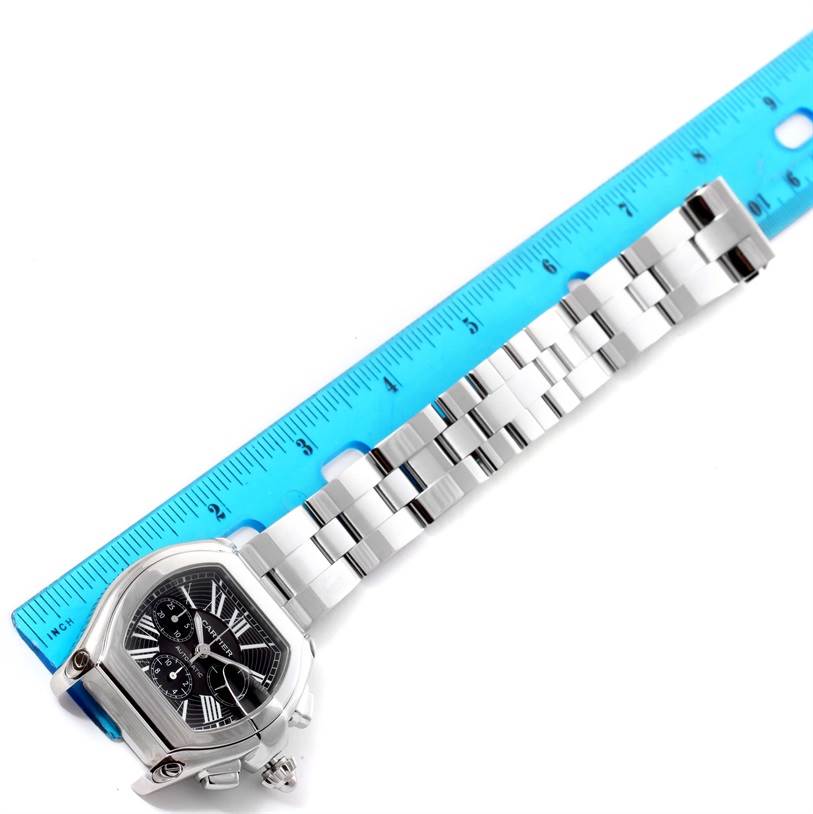 The Cartier Roadster W62020X6 Men's Stainless Steel Black Dial W62020X6 Men's Stainless Steel Black Dial watch is shown at an oblique angle with a focus on the face, bezel, and bracelet against a ruler.