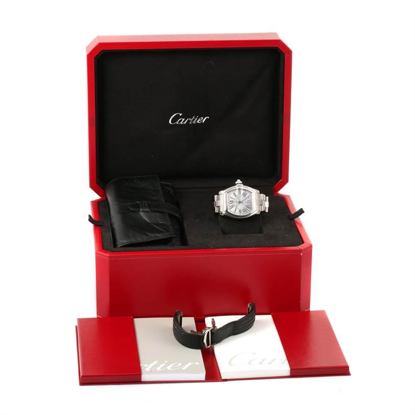 The Cartier Roadster W62032X6 Men's Stainless Steel Silver Dial W62032X6 Men's Stainless Steel Silver Dial watch is displayed in its box along with accessories such as a leather strap and pouch.