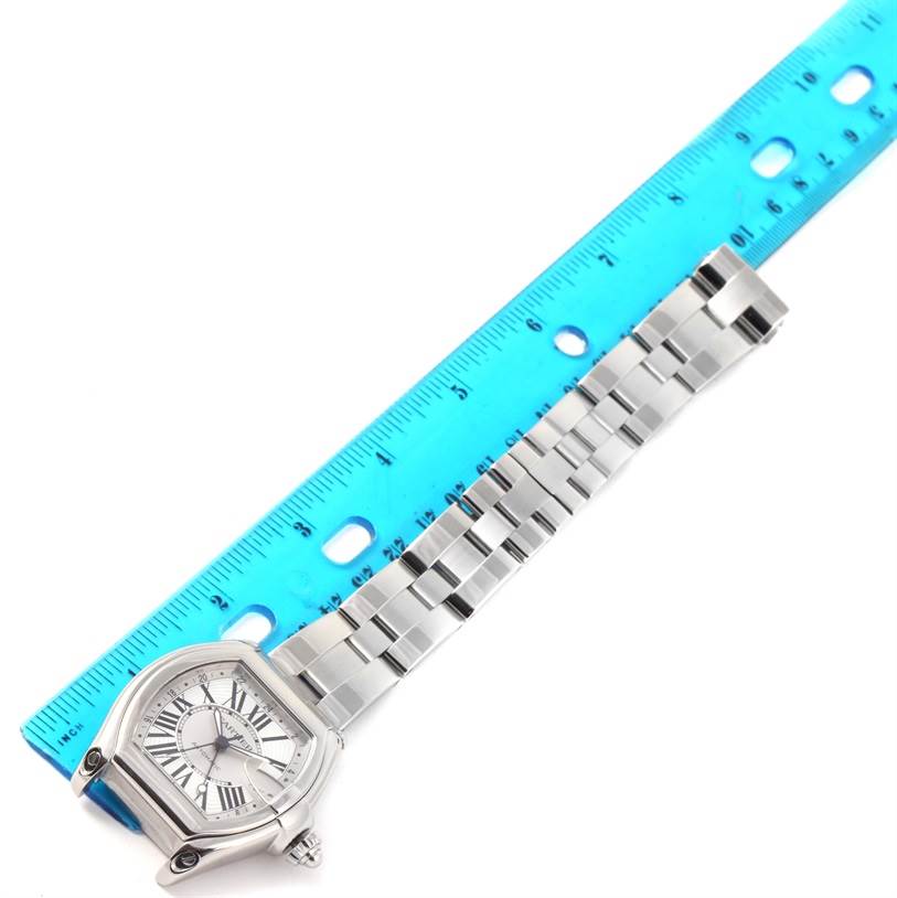 The Cartier Roadster W62032X6 Men's Stainless Steel Silver Dial W62032X6 Men's Stainless Steel Silver Dial watch is shown at an angled view, displaying its face and the linked bracelet alongside a ruler for scale.