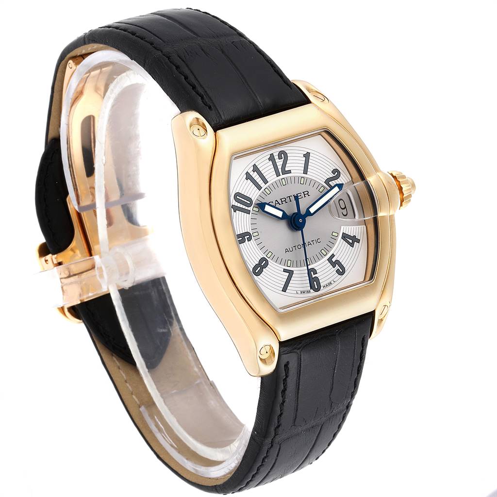 The Cartier Roadster W62005V2 Men's Yellow Gold Silver Dial W62005V2 Men's Yellow Gold Silver Dial watch is shown at a three-quarter angle, highlighting its gold case, black leather strap, and blue hands.