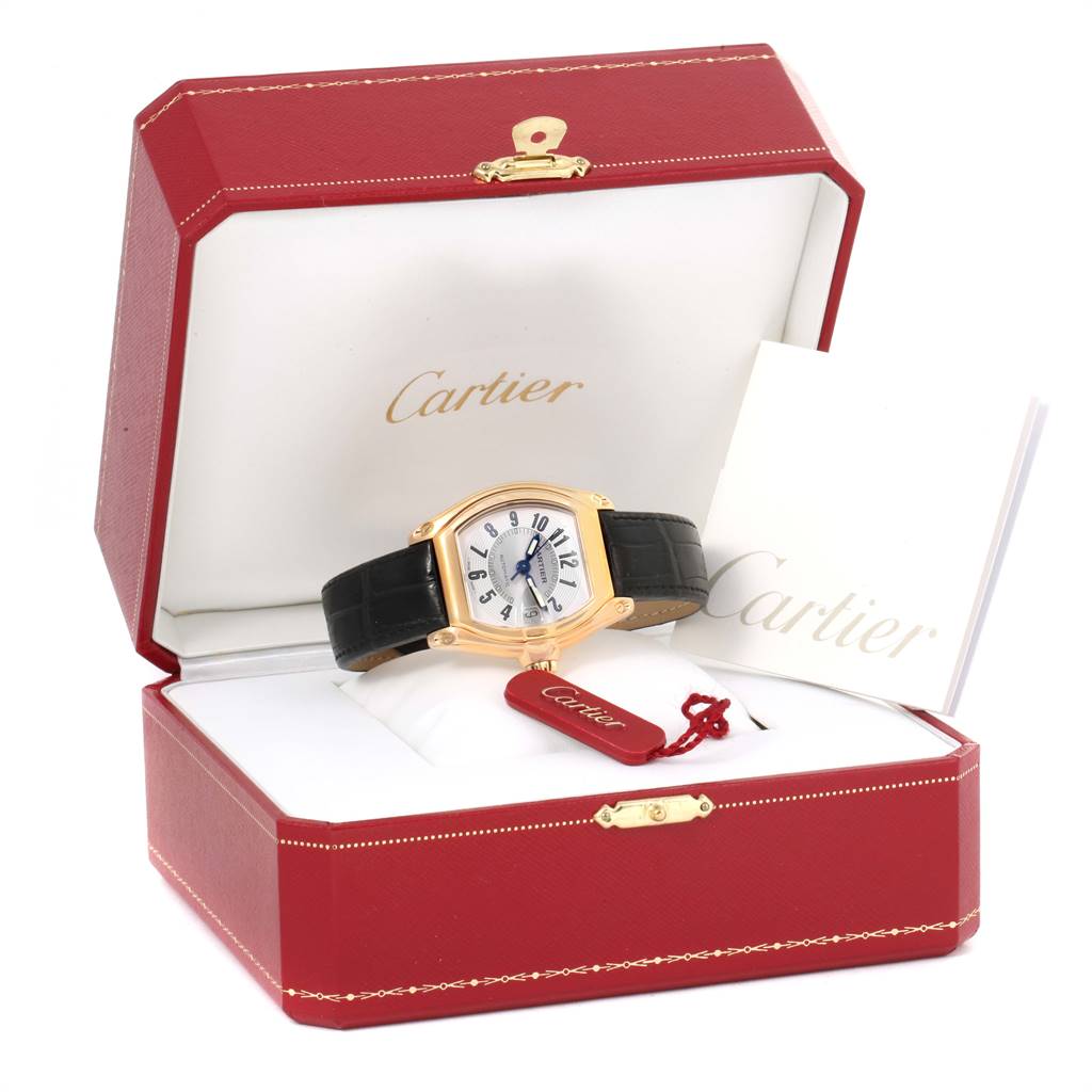 The Cartier Roadster W62005V2 Men's Yellow Gold Silver Dial W62005V2 Men's Yellow Gold Silver Dial watch is shown at a front angle in its open red box, with accompanying booklets and a tag.