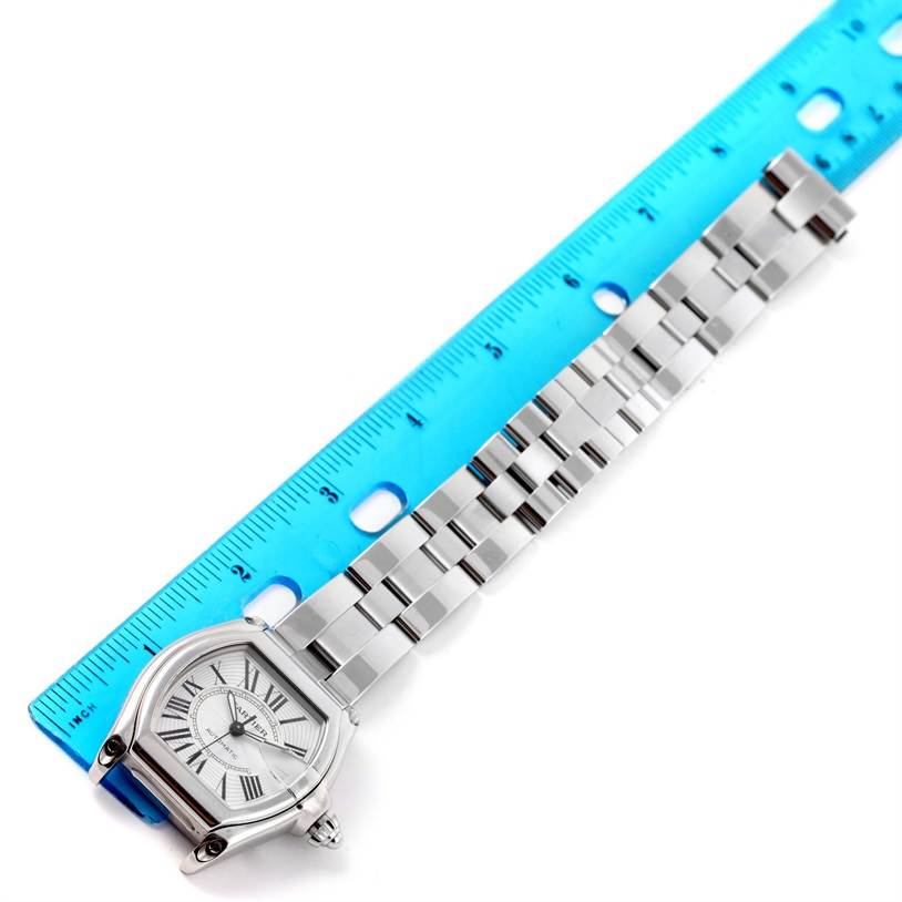 The image shows a top view of a Cartier Roadster W62025V3 Men's Stainless Steel Silver Dial W62025V3 Men's Stainless Steel Silver Dial watch next to a blue ruler for scale.