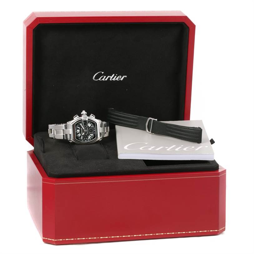 The Cartier Roadster W62007X6 Men's Stainless Steel Black Dial W62007X6 Men's Stainless Steel Black Dial watch is displayed in its open box with an additional strap and booklet.