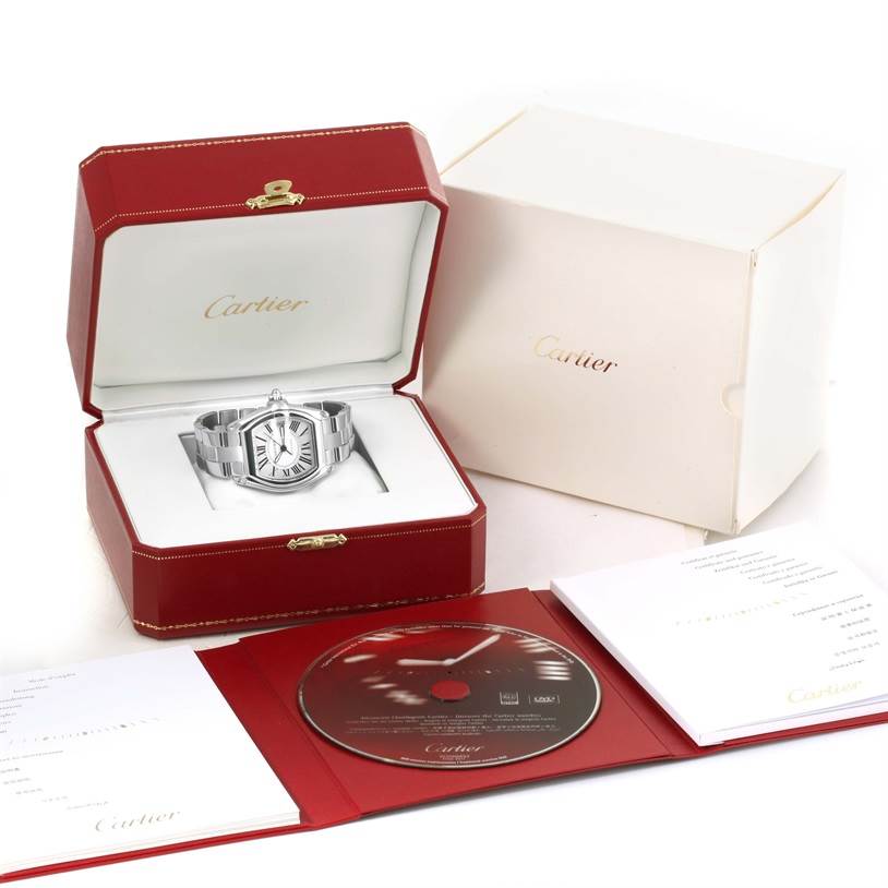 The Cartier Roadster W62025V3 Men
s Stainless Steel Silver Dial W62025V3 Men
s Stainless Steel Silver Dial watch is shown in its open red case, alongside the outer packaging, booklet, and a CD.