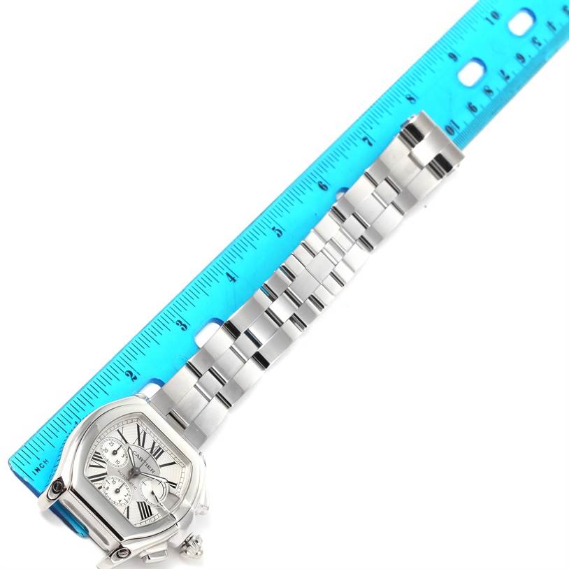 The Cartier Roadster W62019X6 Men
s Stainless Steel Silver Dial W62019X6 Men
s Stainless Steel Silver Dial watch is shown at a top-down angle, highlighting its face, bezel, and stainless steel bracelet alongside a ruler.