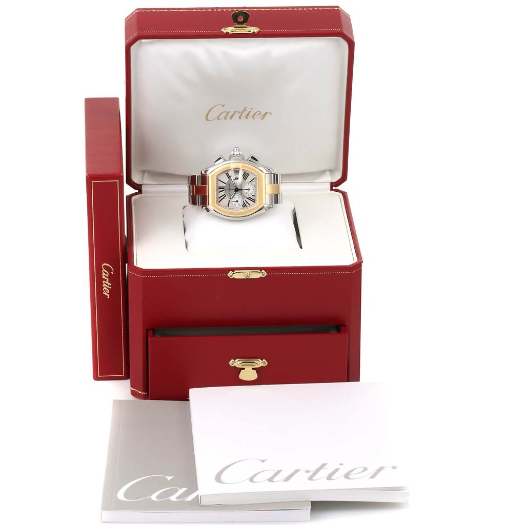 The Cartier Roadster W62027Z1 Men's Steel and Gold (two tone) Silver Dial W62027Z1 Men's Steel and Gold (two tone) Silver Dial watch is displayed inside an open red box with booklets and outer packaging visible.
