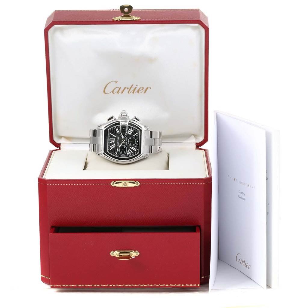 The Cartier Roadster W62020X6 Men
s Stainless Steel Black Dial W62020X6 Men
s Stainless Steel Black Dial watch is displayed front-on in its red box with a white interior and includes a documentation booklet beside it.