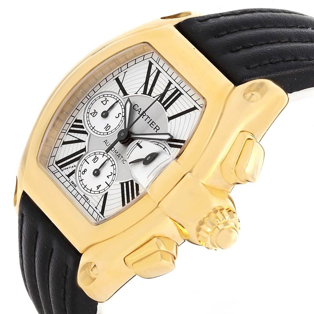 The image shows a close-up, angled view of a Cartier Roadster W62021Y2 Men's Yellow Gold Silver Dial W62021Y2 Men's Yellow Gold Silver Dial watch, highlighting its dial, crown, and part of the strap.