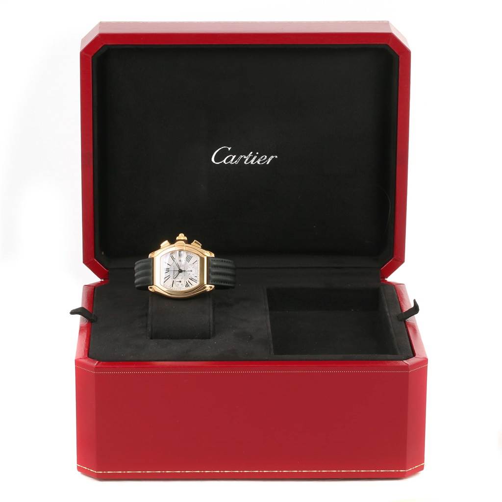 The Cartier Roadster W62021Y2 Men's Yellow Gold Silver Dial W62021Y2 Men's Yellow Gold Silver Dial watch is displayed inside its open red and black box, showing the face and band.