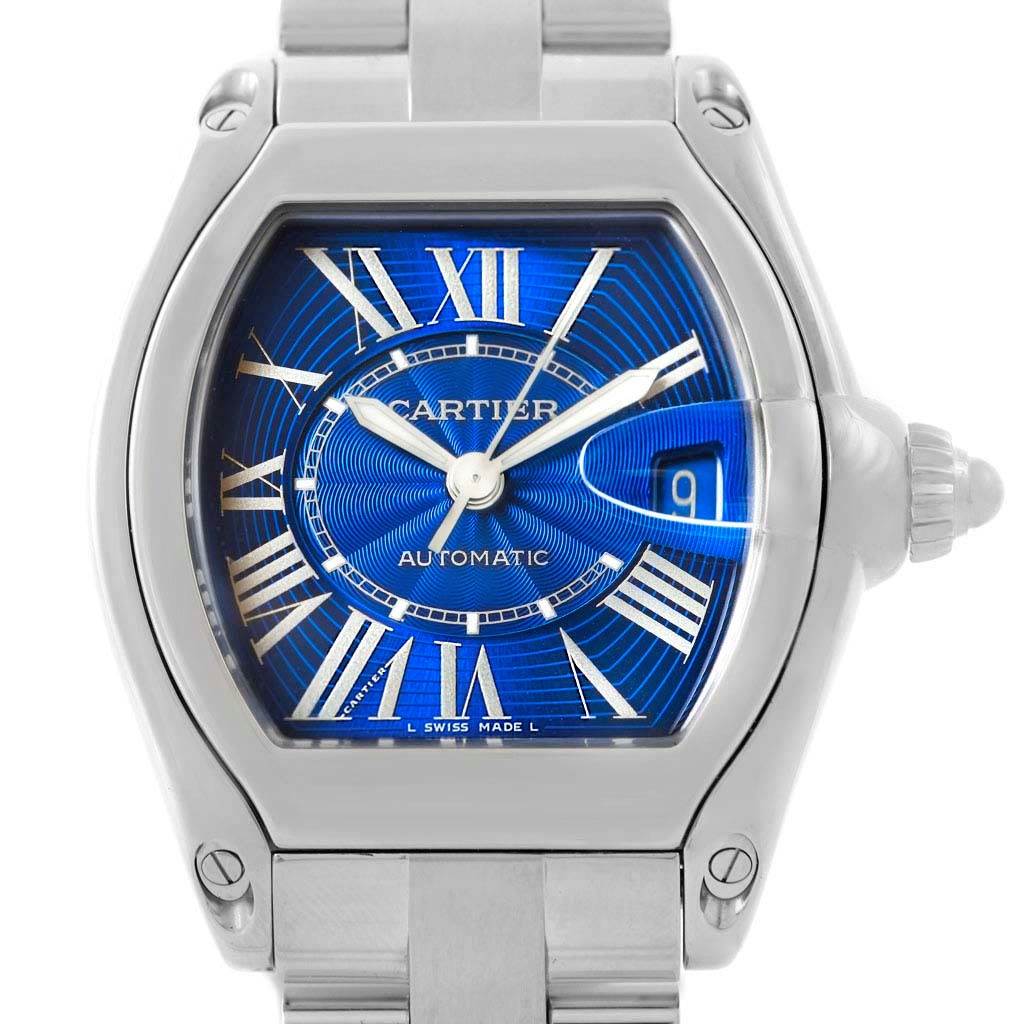 The image shows a front view of a Cartier Roadster W62048V3 Men
s Stainless Steel Blue Dial W62048V3 Men
s Stainless Steel Blue Dial watch, highlighting its blue dial, Roman numerals, and date window at 3 o
clock.
