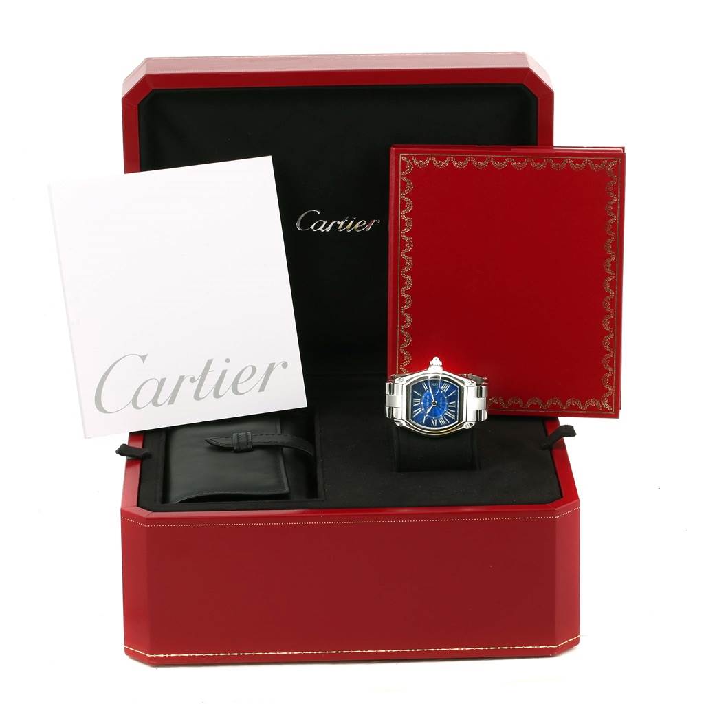 The Cartier Roadster W62048V3 Men
s Stainless Steel Blue Dial W62048V3 Men
s Stainless Steel Blue Dial watch is shown front-facing with its box, a red booklet, a white envelope, and a black pouch.