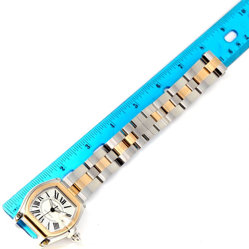 This image shows the face and full band of the Cartier Roadster W62031Y4 Men's Steel and Gold (two tone) Silver Dial W62031Y4 Men's Steel and Gold (two tone) Silver Dial watch, placed next to a blue ruler for scale.