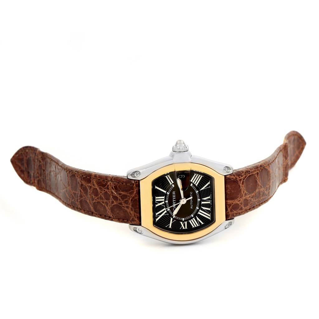 The image shows a Cartier Roadster W62031Y4 Men's Steel and Gold (two tone) Black Dial W62031Y4 Men's Steel and Gold (two tone) Black Dial watch with a black dial and a brown leather strap from a front, top-down angle.