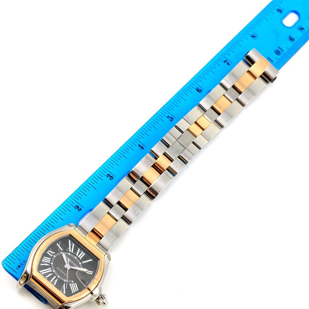 The Cartier Roadster W62031Y4 Men's Steel and Gold (two tone) Black Dial W62031Y4 Men's Steel and Gold (two tone) Black Dial watch is shown lying flat with its two-tone metal bracelet next to a ruler for scale.