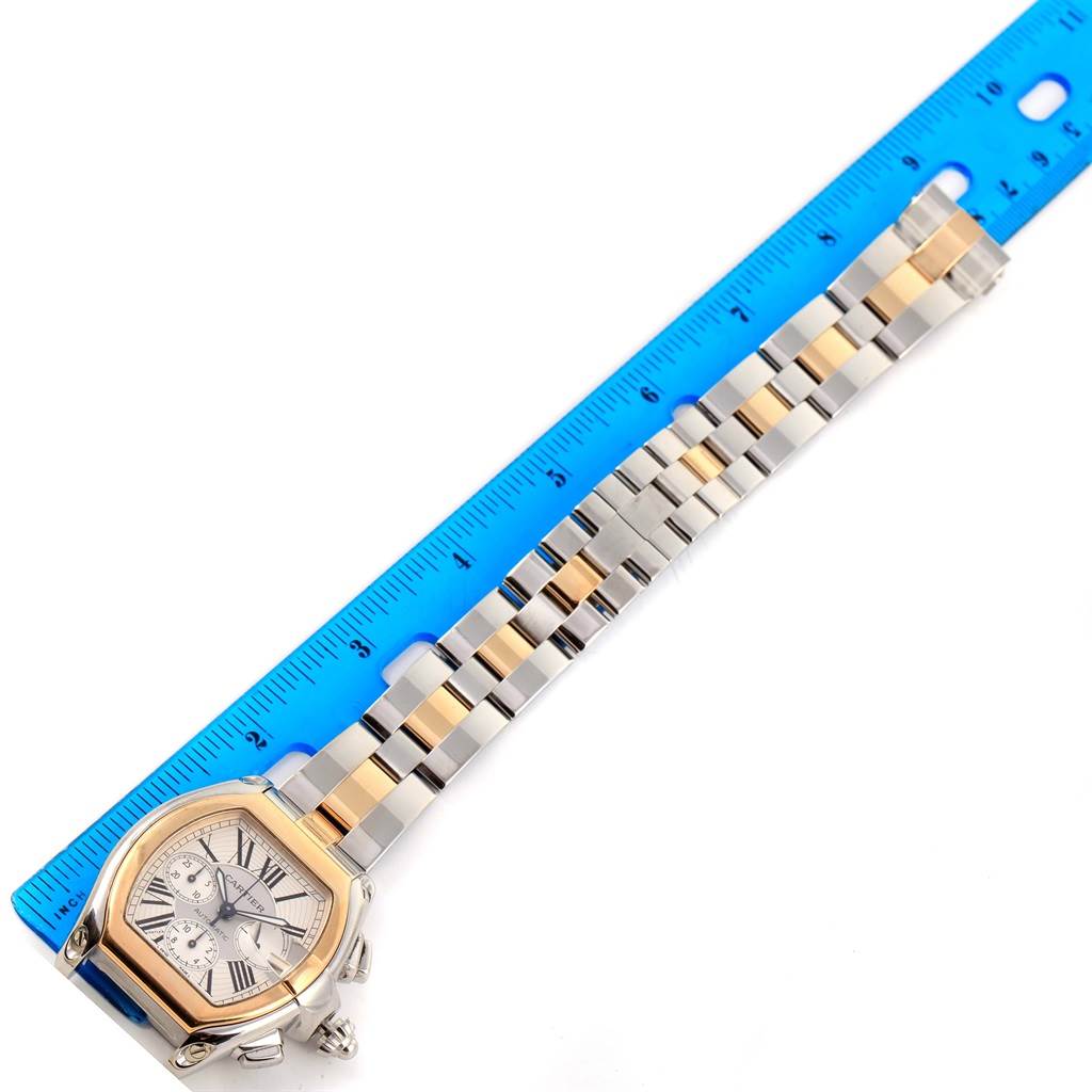 The Cartier Roadster W62027Z1 Men's Steel and Gold (two tone) Silver Dial W62027Z1 Men's Steel and Gold (two tone) Silver Dial watch is shown from an overhead angle, displaying the face and full bracelet with a ruler for scale.