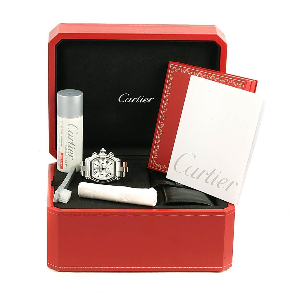 The Roadster model by Cartier is shown in its open case with accessories, including a cleaning brush, cloth, and documentation.