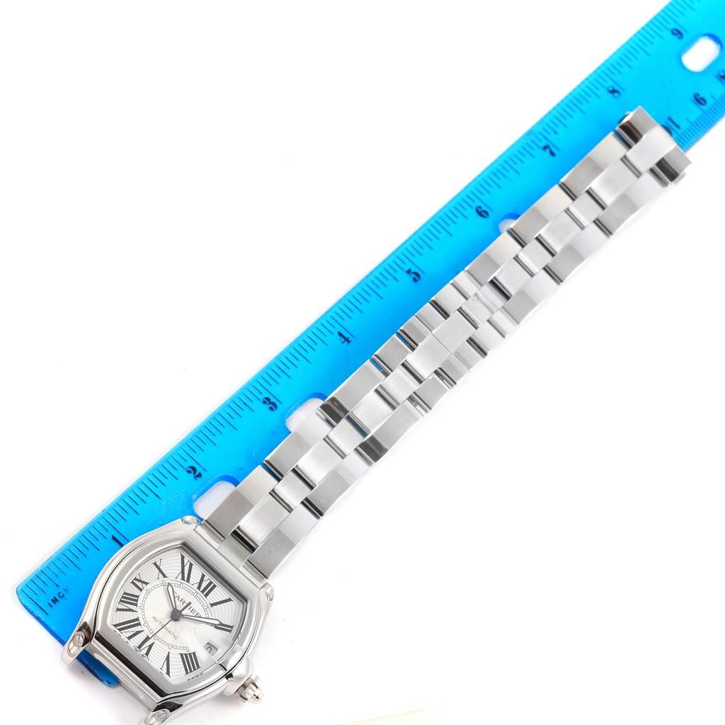 The Cartier Roadster W62025V3 Men
s Stainless Steel Silver Dial W62025V3 Men
s Stainless Steel Silver Dial watch is shown from a top-down angle, displaying the face, case, and metal strap aligned with a ruler.