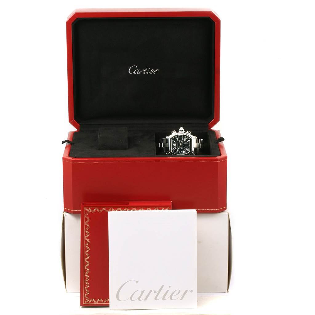 The Cartier Roadster W62020X6 Men's Stainless Steel Black Dial W62020X6 Men's Stainless Steel Black Dial watch is shown front-facing in its open box, along with booklets in front of the box.
