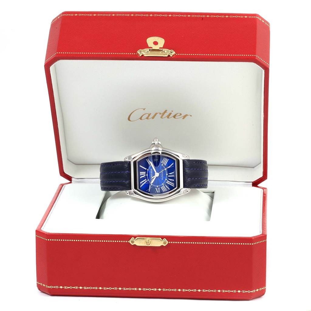 The Cartier Roadster W62048V3 Men's Stainless Steel Blue Dial W62048V3 Men's Stainless Steel Blue Dial watch is displayed front-on in a red Cartier box with a blue dial and black strap.