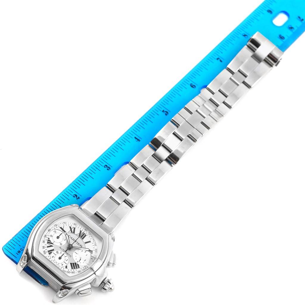 The image shows a top-down view of the Cartier Roadster W62006X6 Men's Stainless Steel Silver Dial W62006X6 Men's Stainless Steel Silver Dial watch with a ruler beside it for scale.