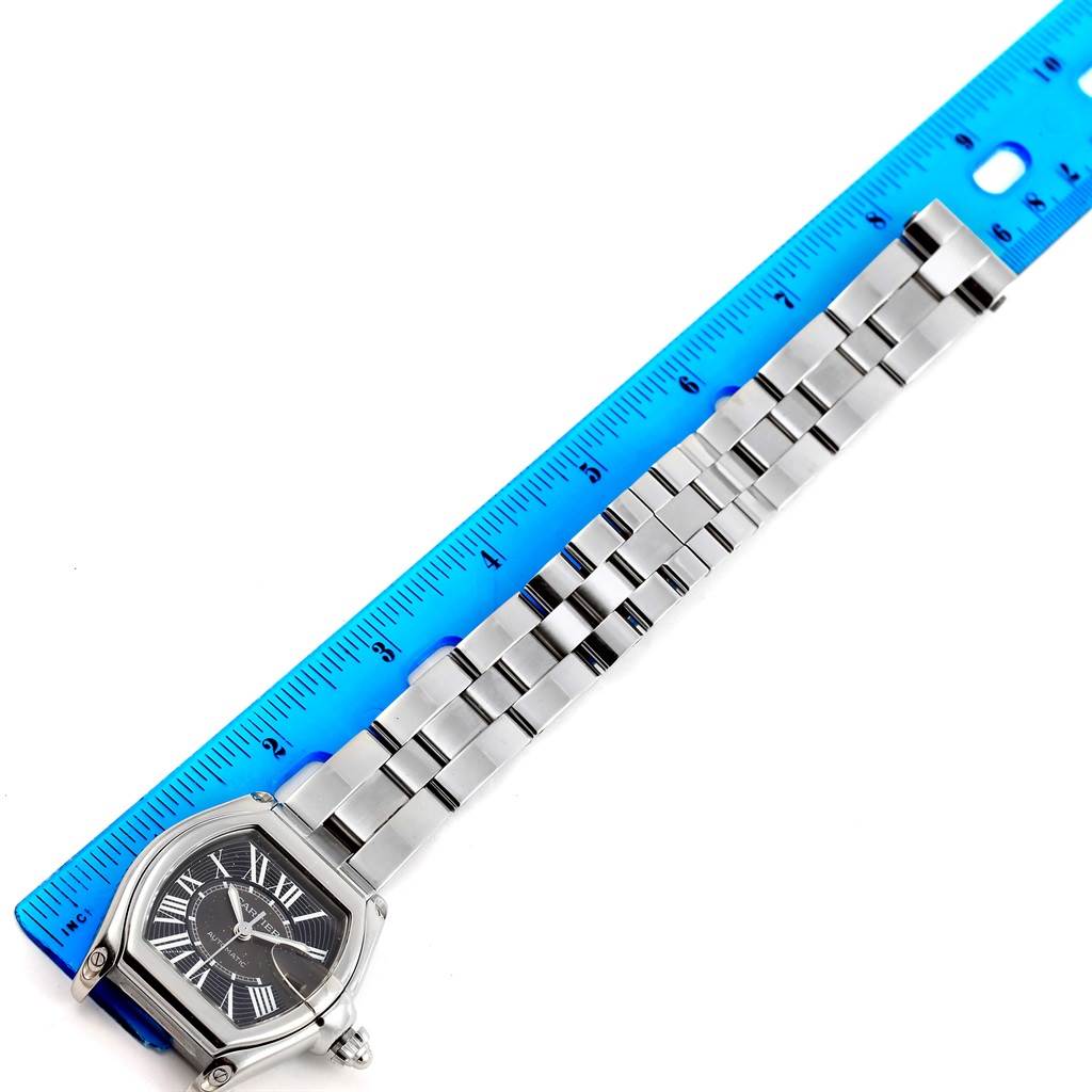 The image shows a Cartier Roadster W62041V3 Men's Stainless Steel Black Dial W62041V3 Men's Stainless Steel Black Dial watch lying flat, with its face and full metal bracelet visible alongside a blue ruler for scale.