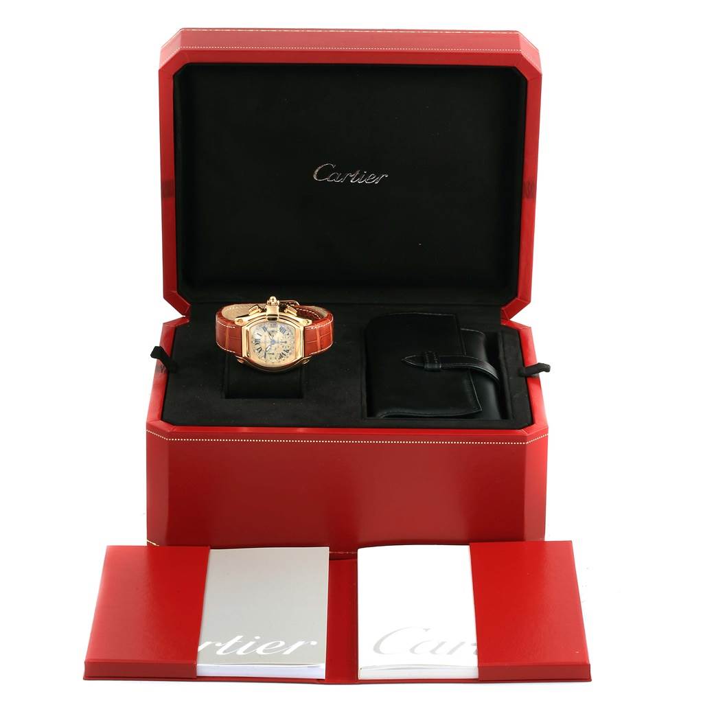 The Cartier Roadster W62021Y3 Men
s Yellow Gold Champagne Dial W62021Y3 Men
s Yellow Gold Champagne Dial watch is shown in its open red box, along with a booklet and additional accessory pouch.