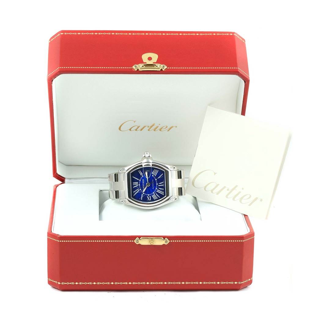 The Cartier Roadster W62048V3 Men's Stainless Steel Blue Dial W62048V3 Men's Stainless Steel Blue Dial watch is displayed front-facing in its branded box with documentation beside it.